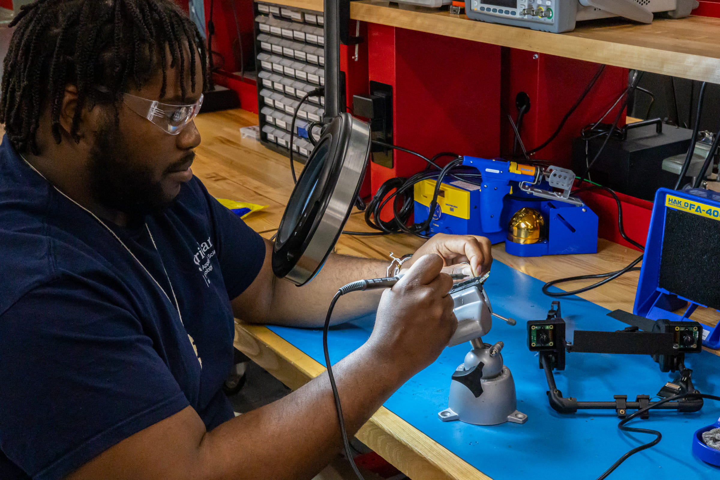 A researcher sits at a table and works on an electronic