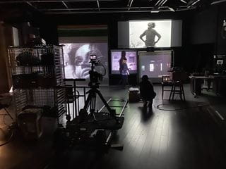 A research space with several large screens displaying black and white images