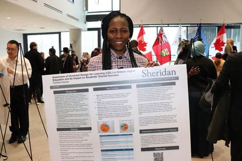 Sheridan student Taofikat Atanda holds a poster that summarizes her research project and key findings
