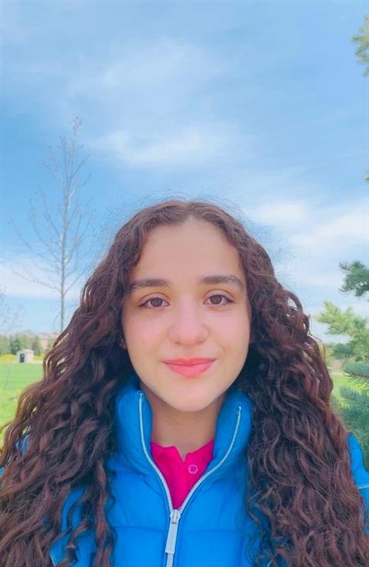 A portrait photo of Carla Farag wearing a blue jacket outside
