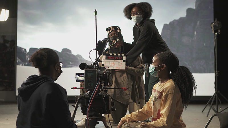 Group of students setting up a camera shot in a studio.