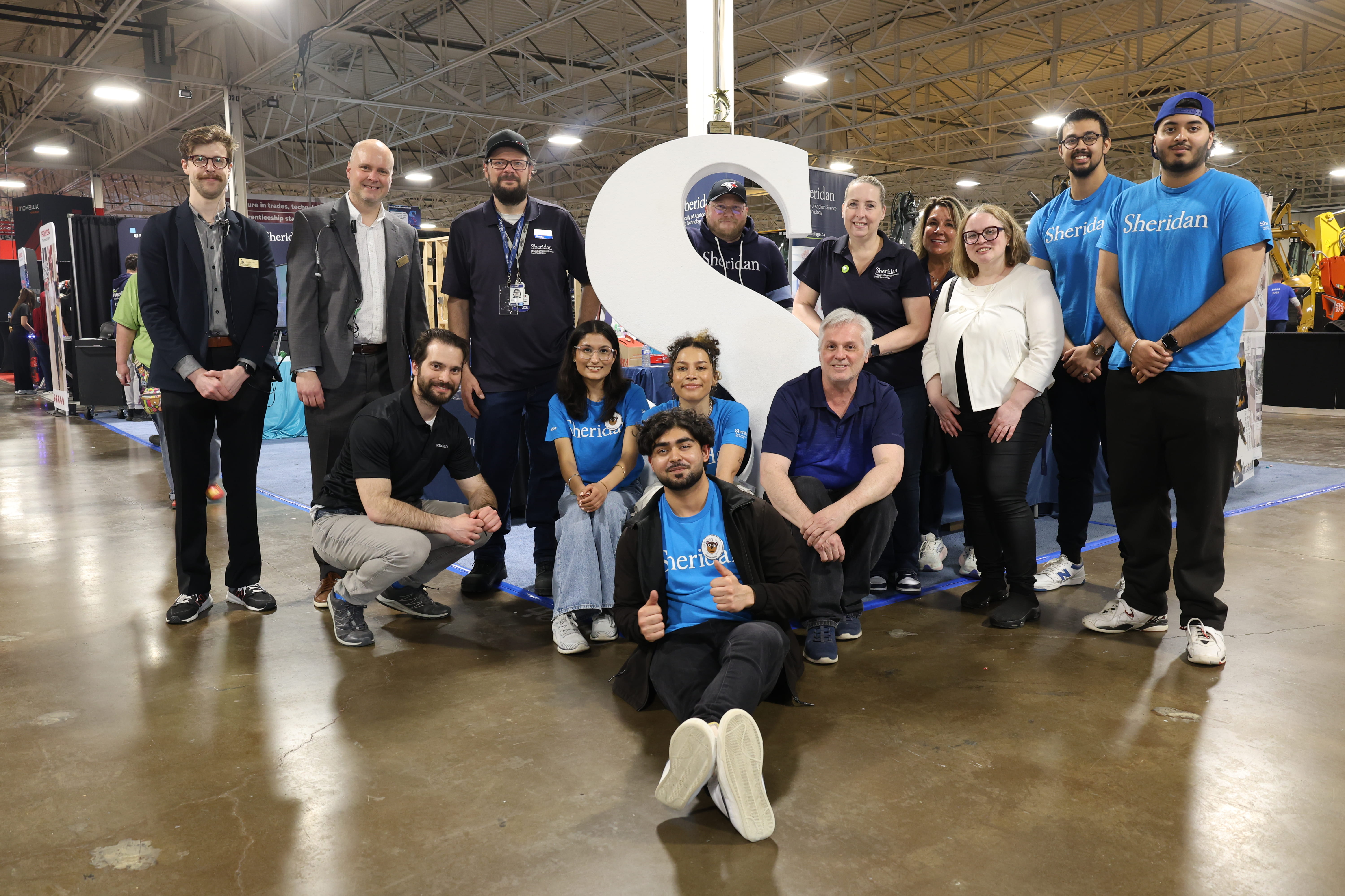 Sheridan staff gather around Sheridan's booth at the Skills Ontario Competition