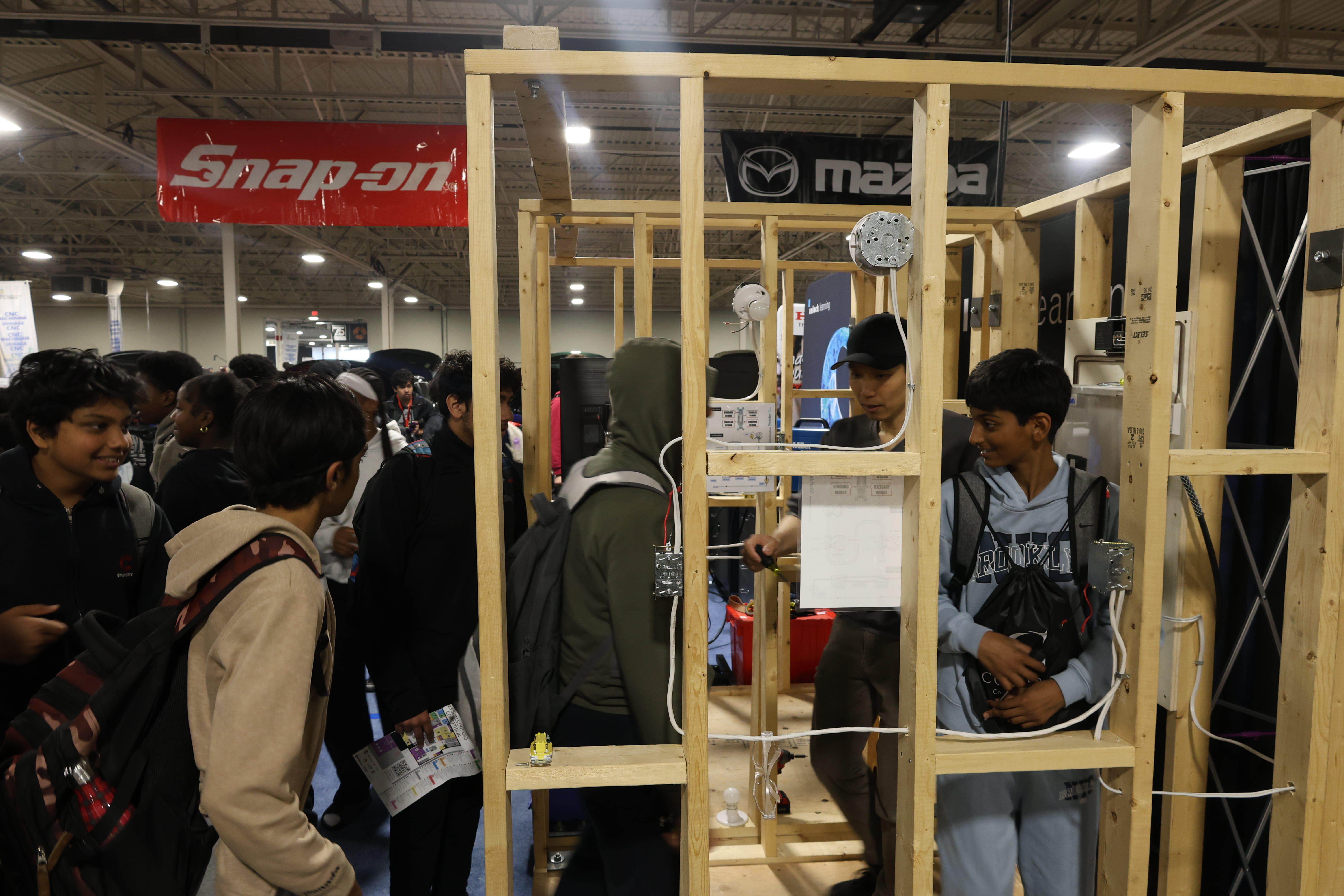 Visitors to Sheridan's booth interact with an electrical wiring simulation