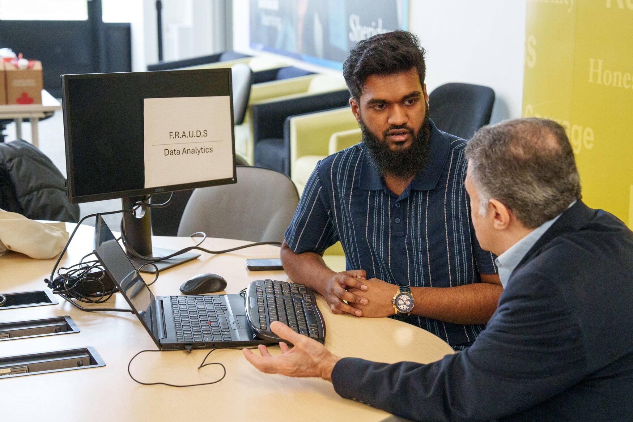 Sheridan Computer Science student Tauheed Shams Tabrez Attar explains his team's F.R.A.U.D.S. project to a showcase attendee