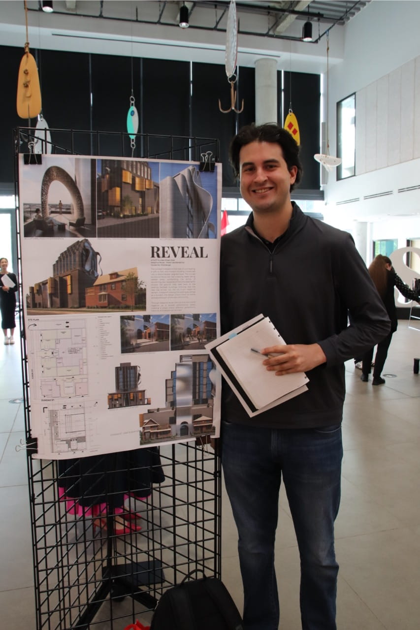 Sheridan student Manolo Mendoza stands beside a display of his project