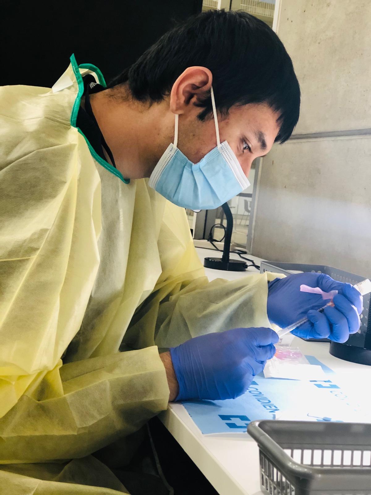 Sheridan Pharmacy Tech student Hamad Kakazai working on reconstituting vaccine