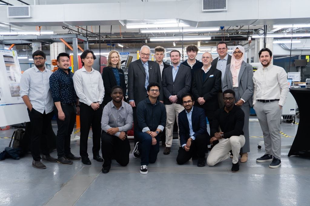 Sheridan mechanical engineering students stand with administrators, faculty and the capstone showcase judge for a photo within Sheridan's Centre for Intelligent Manufacturing.
