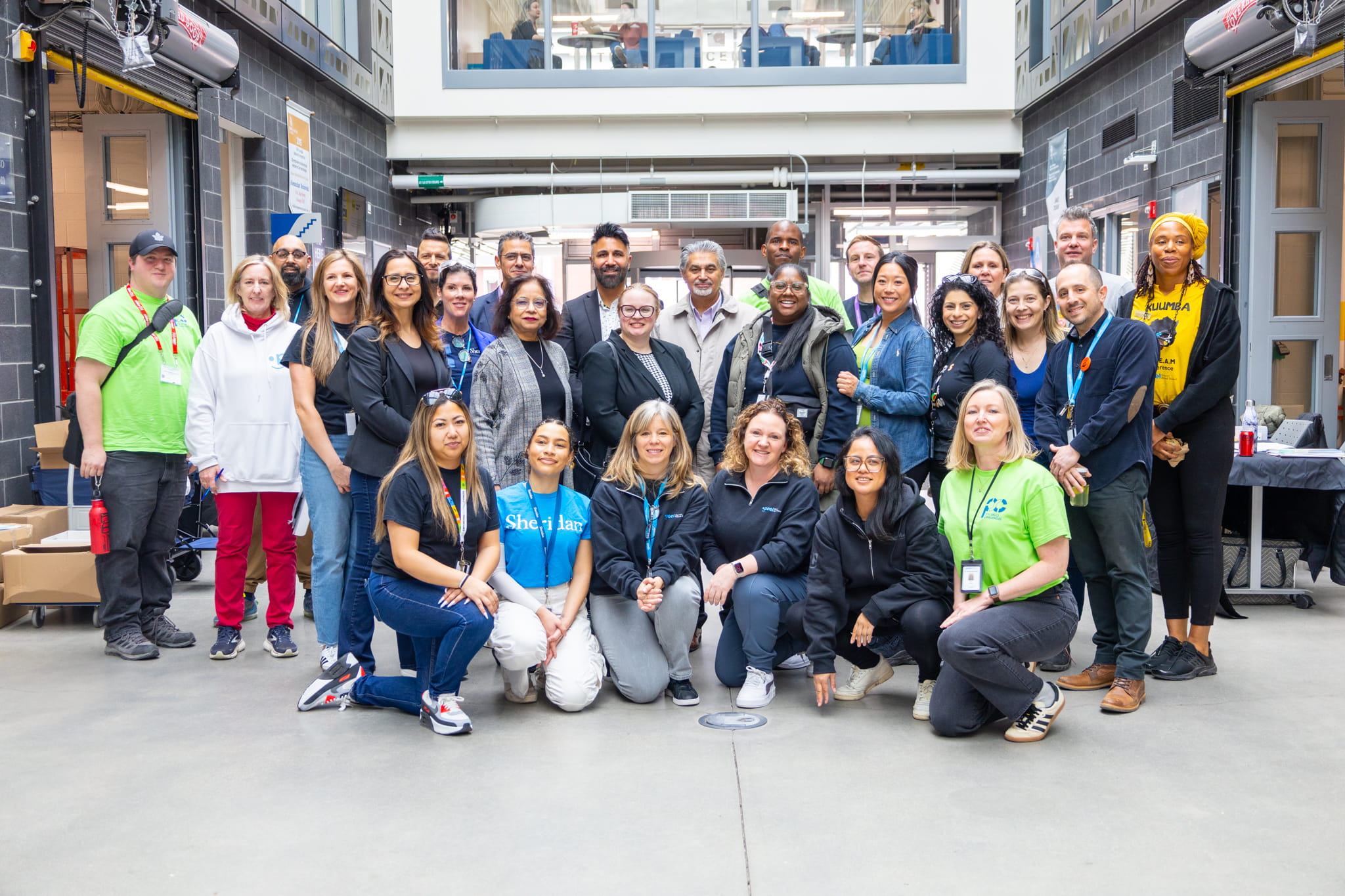 A group of PDSB and Sheridan staff posing in the Magna Skilled Trades Centre. 