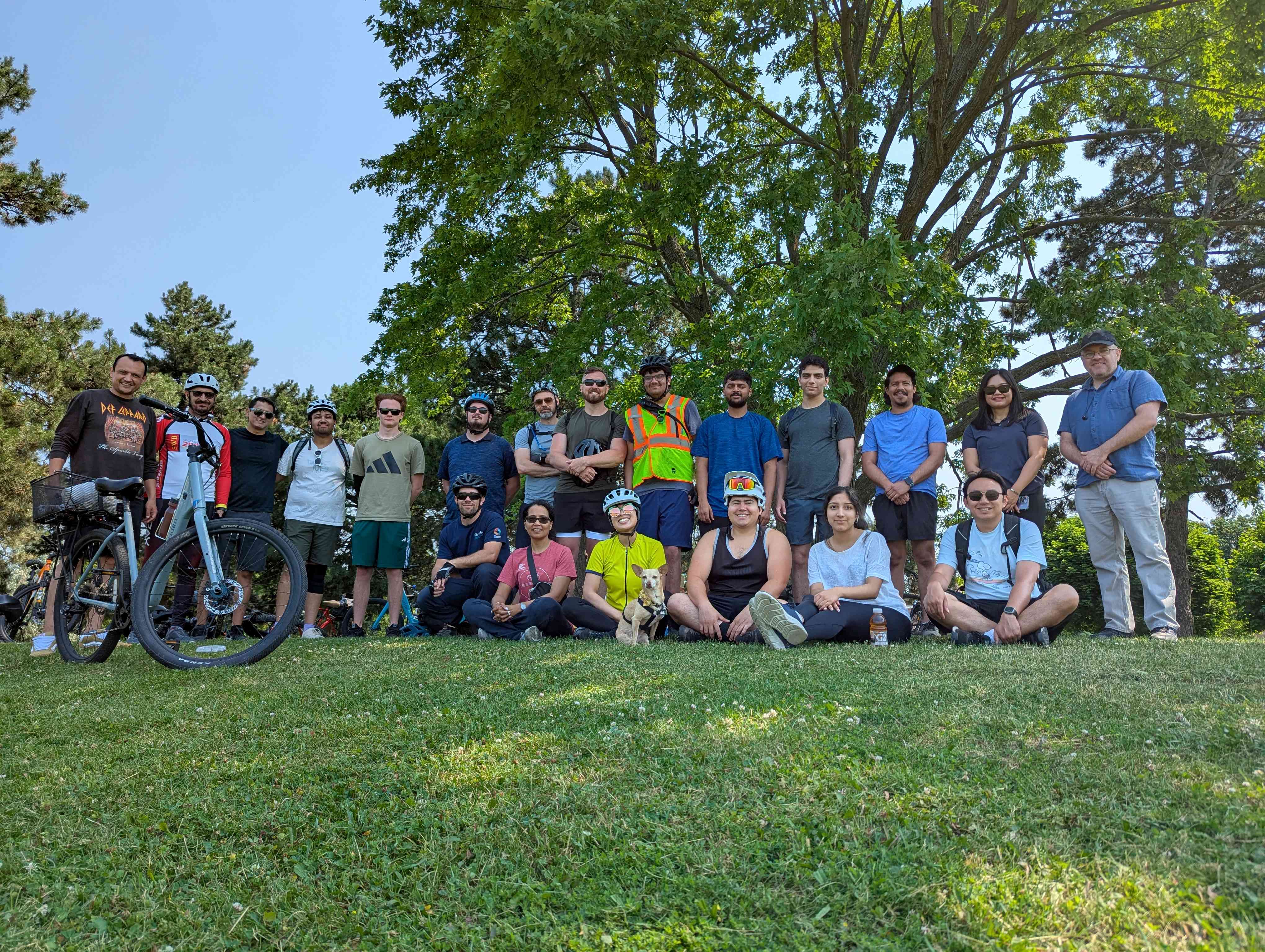 The group of cyclists from the Tour de Sheridan event pose together in a park.