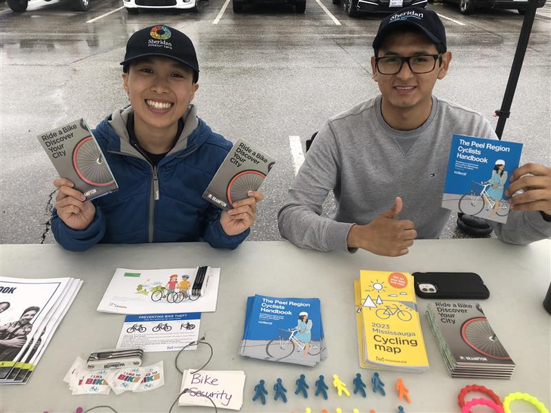 Two people sit at a table with information about cycling