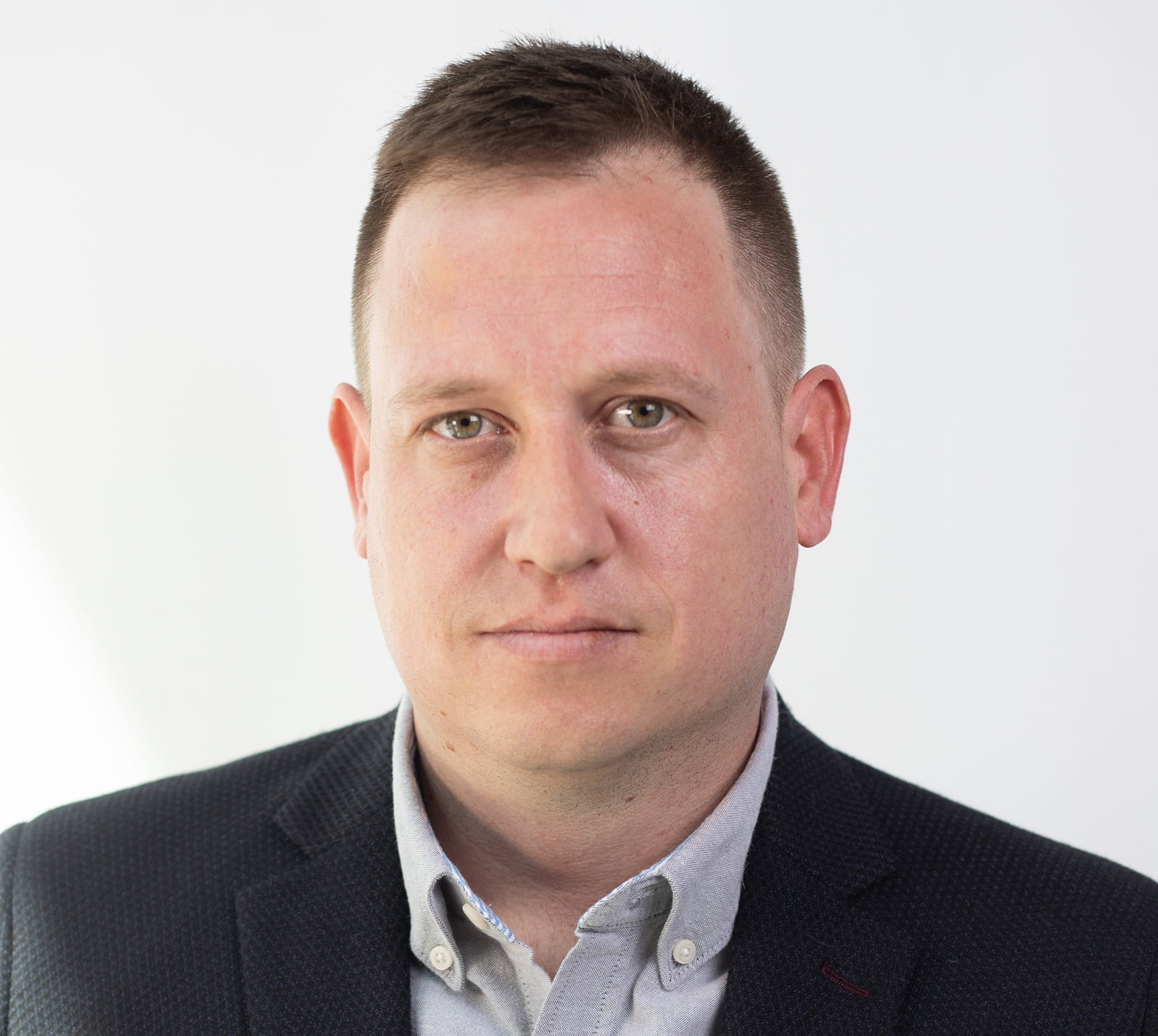 Headshot of Sheridan professor and researcher Dr. Nathaniel Barr wearing a button up shirt and blazer