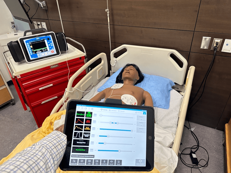 An instructor uses the Monitor by Laerdal defibrillator simulator on a mannequin in Sheridan's nursing lab