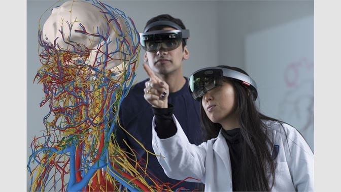 Two students view a holographic display of human anatomy using HoloAnatomy 3D mixed reality software