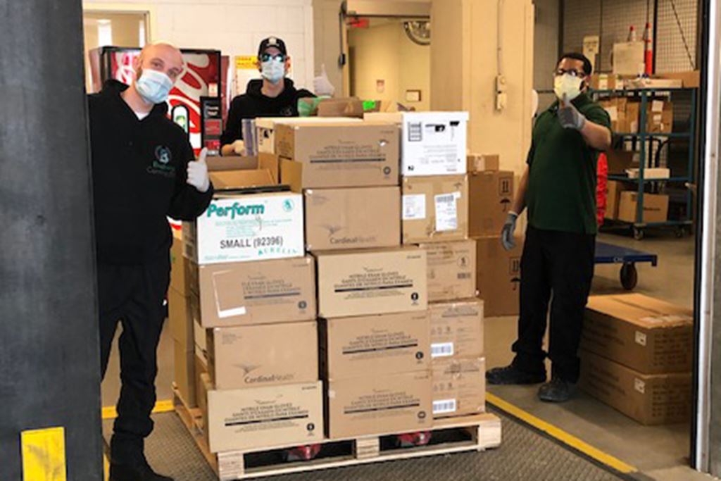 Staff standing with boxes of protective equipment being shipped out to hospitals from Sheridan College