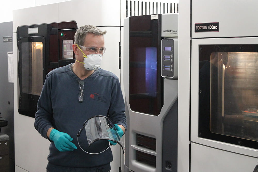 Simon Heathcote holding a shield 3D-printed in Sheridan's Centre for Advanced Manufacturing and Design Technologies in Brampton