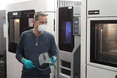 Simon Heathcote holding a shield 3D-printed in Sheridan's Centre for Advanced Manufacturing and Design Technologies in Brampton