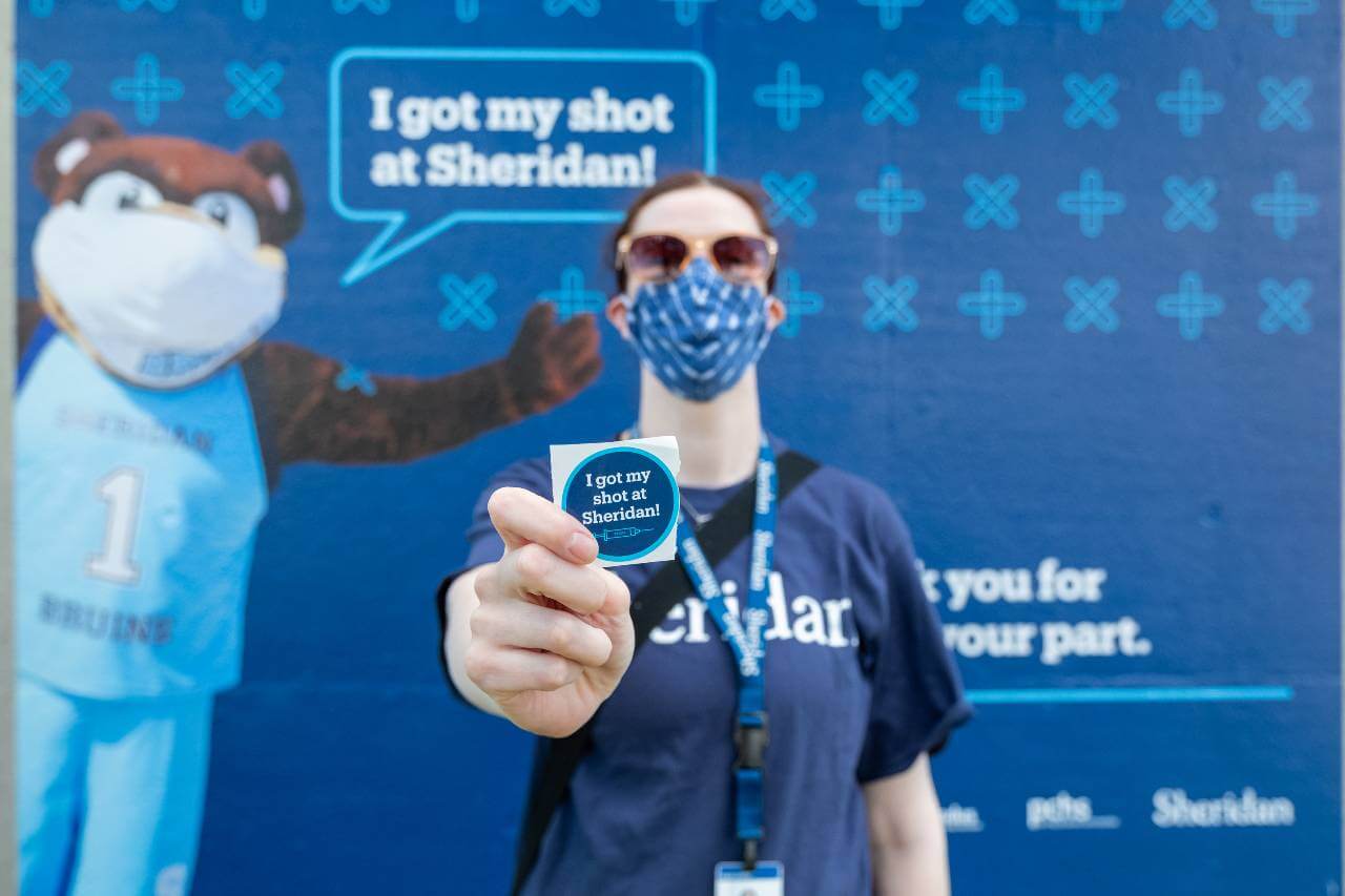 Sheridan Vaccine Clinic guest with I got my shot sticker