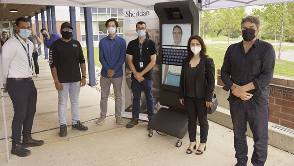 Researchers and project partners pose with the Animated Virtual Agent.