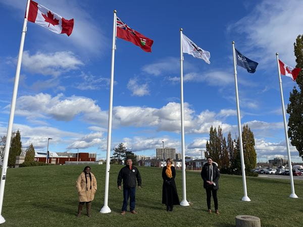 Dignitaries pose by flags