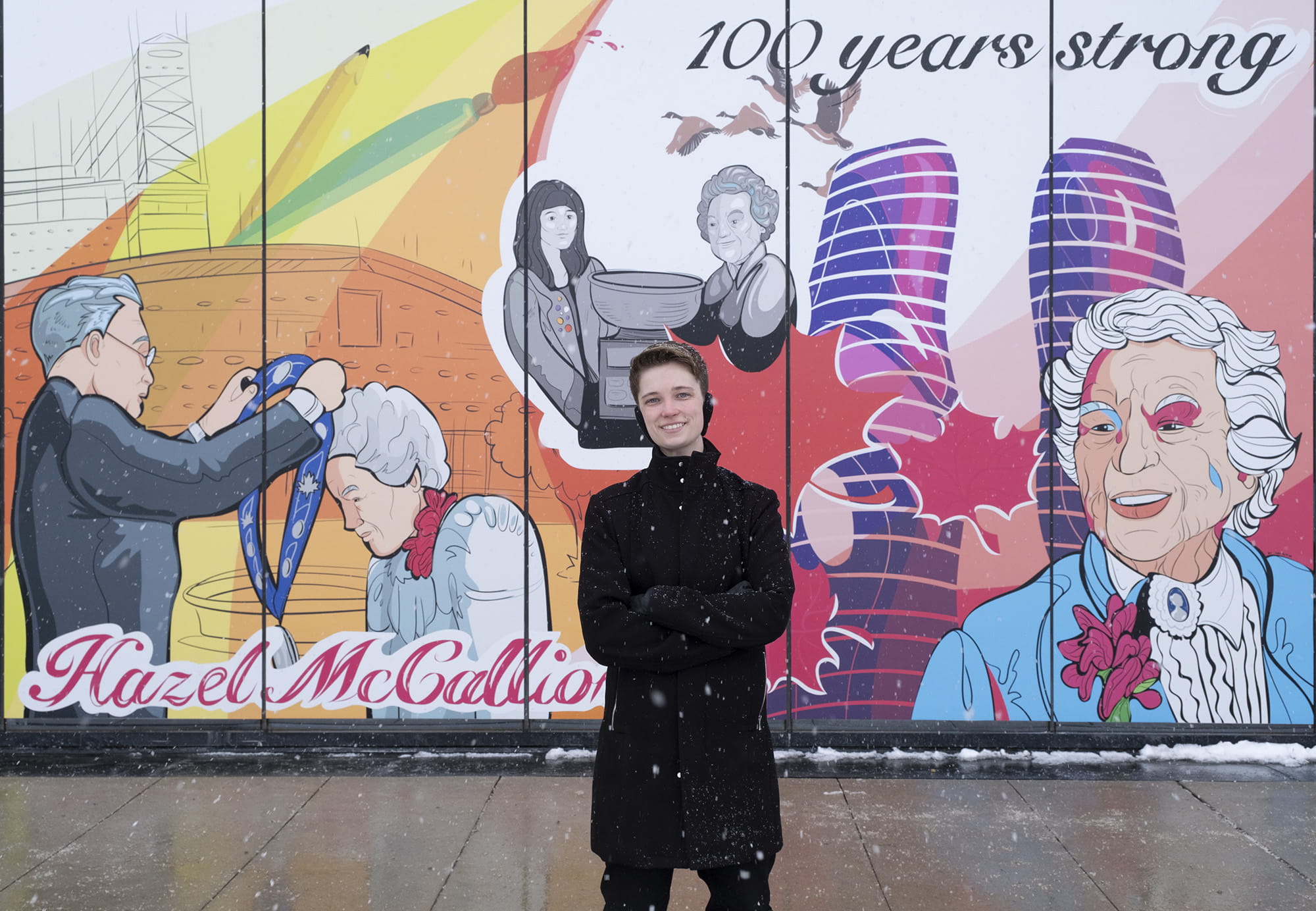 Jude Phillips standing in front of the mural he designed for Hazel McCallion