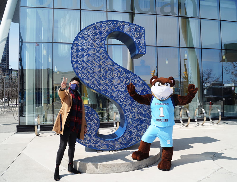 Wali Shah and Bruno - Sheridan's mascot - standing in front of the Sheridan S statue at the Hazel McCallion Campus
