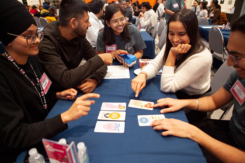 People pointing at cards on a table