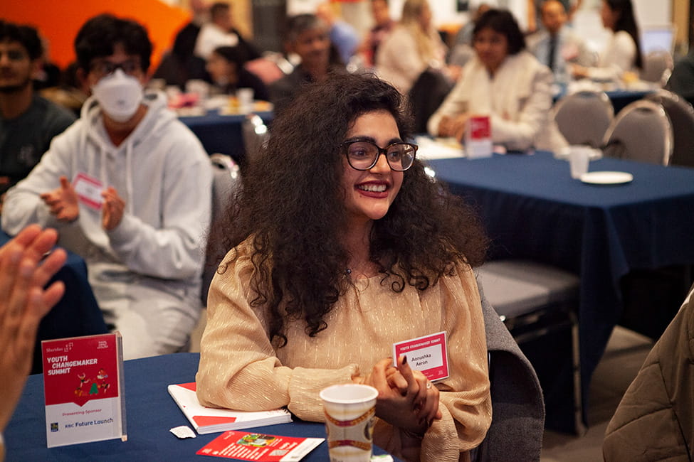 Person seated at a table and smiling