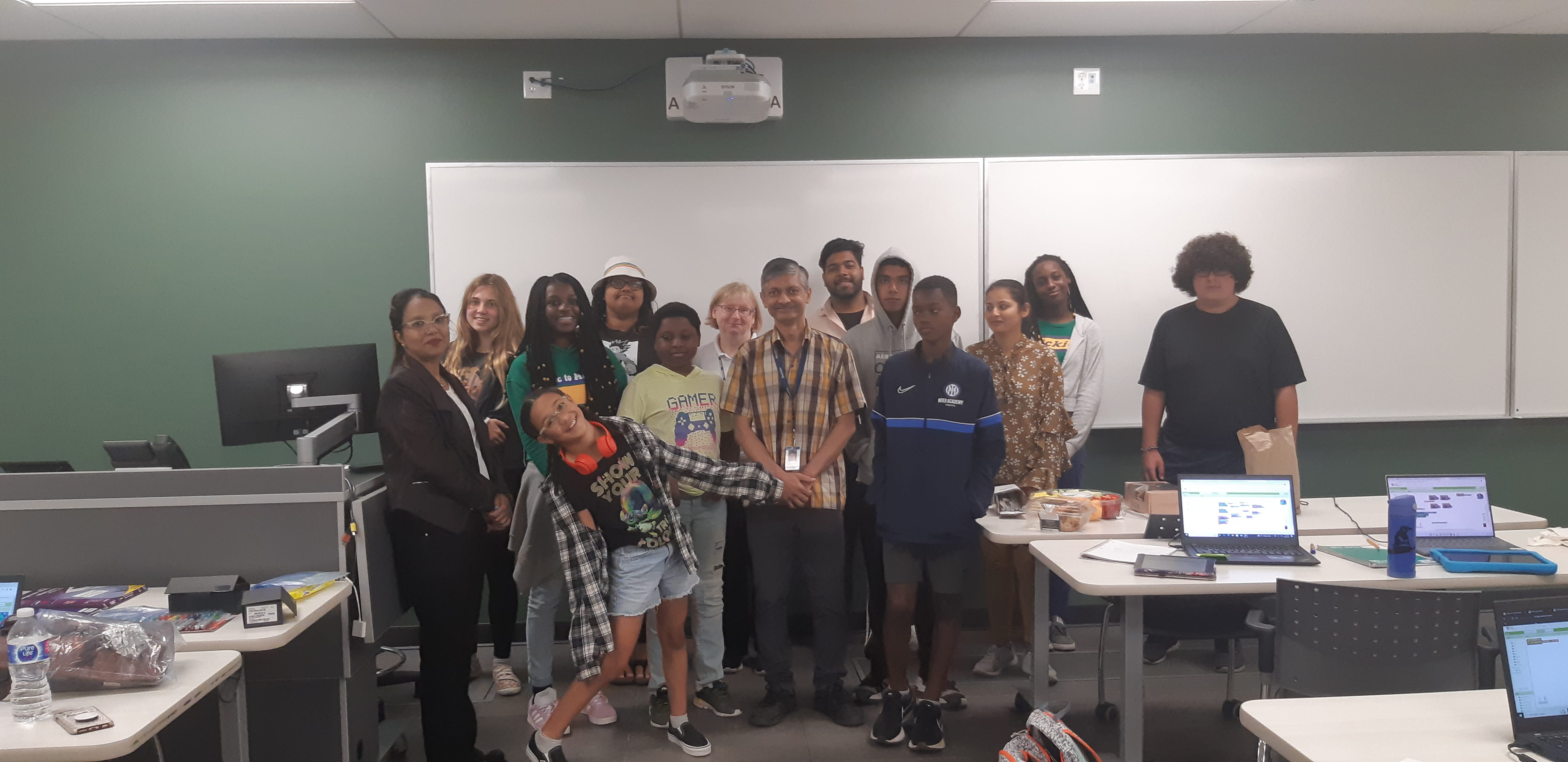 Sheridan professor surrounded by a group of youth who were participants in an app development summer camp