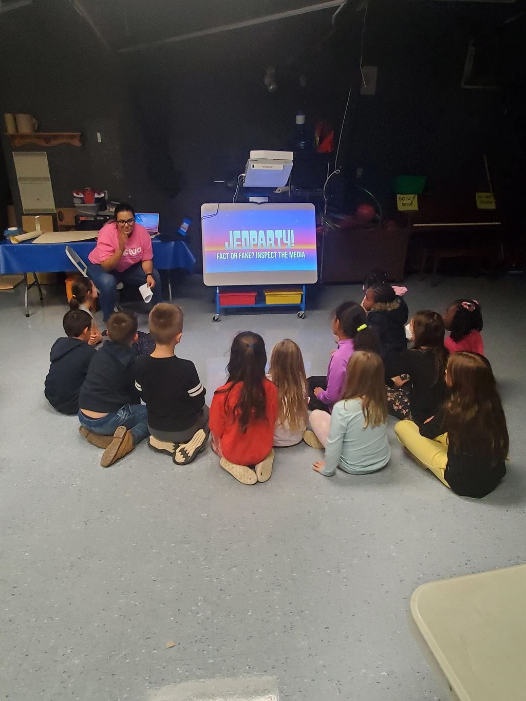 A Sheridan student teaching a group of youth seated on the floor