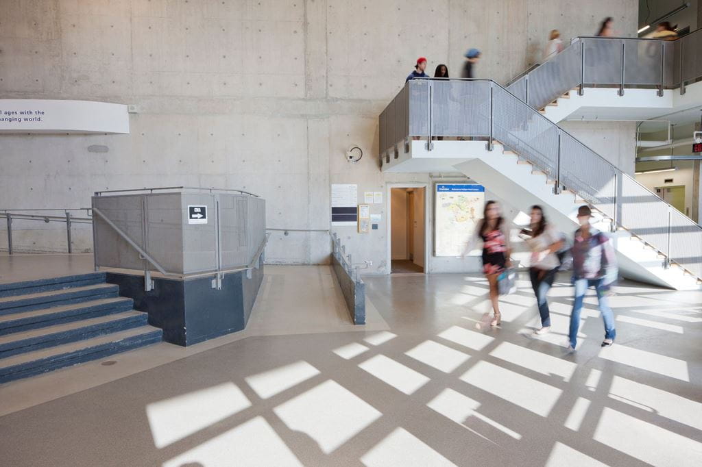 Students walk across the foyer of a building on Sheridan's Trafalgar Road Campus