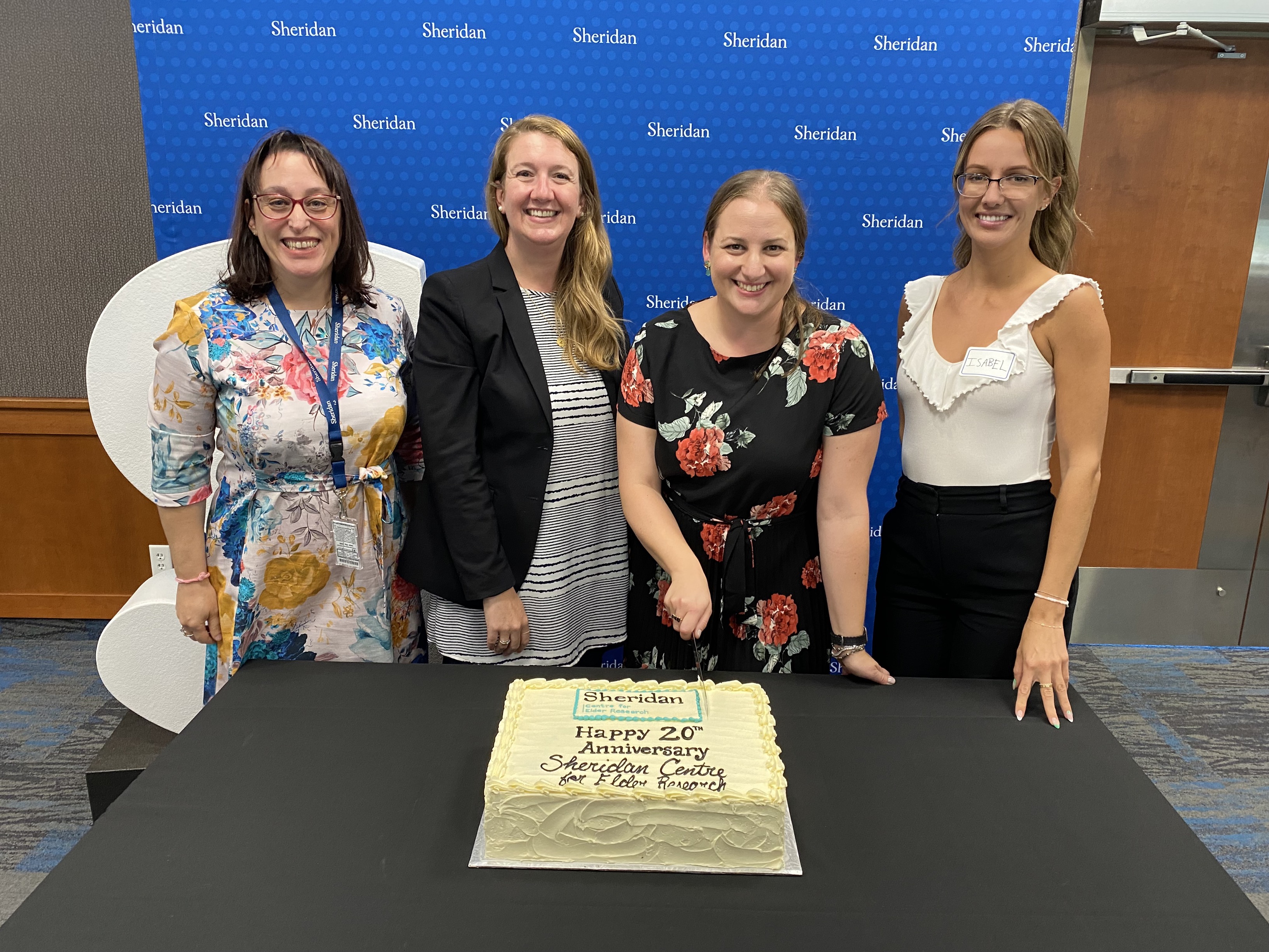 Staff from the Sheridan Centre for Elder Research prepare to cut a cake celebrating the centre's 20th anniversary.