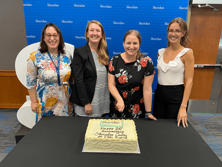 Staff from the Sheridan Centre for Elder Research prepare to cut a cake celebrating the centre's 20th anniversary.