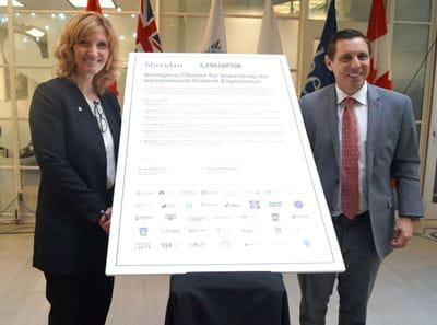 Janet Morrison and Patrick Brown stand with signed charter