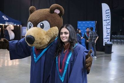 Mascot Bruno poses with a student in the reception area of convocation