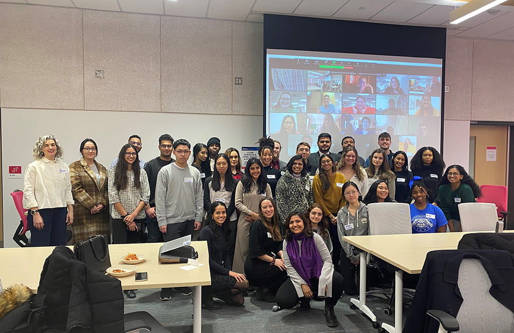 Cohort of Social Impact Catalyst participants at EDGE in front of a screen with virtual participants