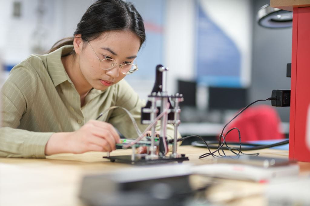 A Sheridan student researcher experiments with an electrical assembly