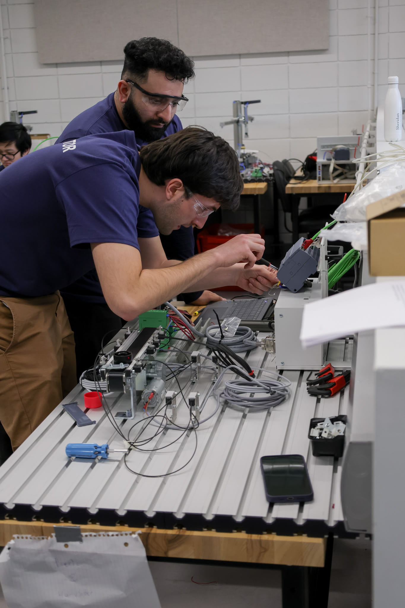 Two electromechanical students work on a challenge