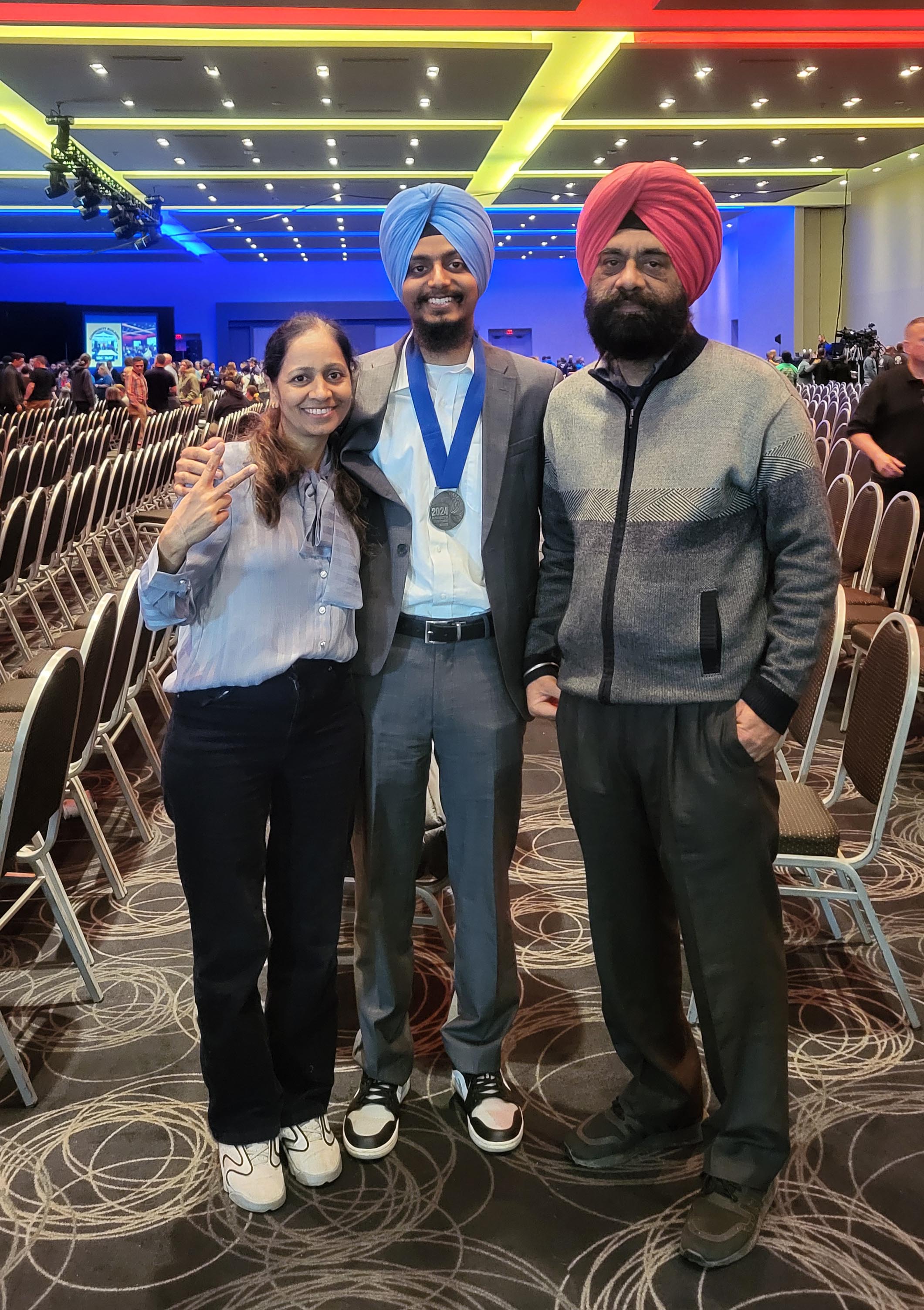 Sheridan student Hardeep Bansal poses for a photo between his mother and father