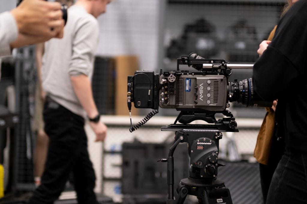 A film camera is set up in a studio