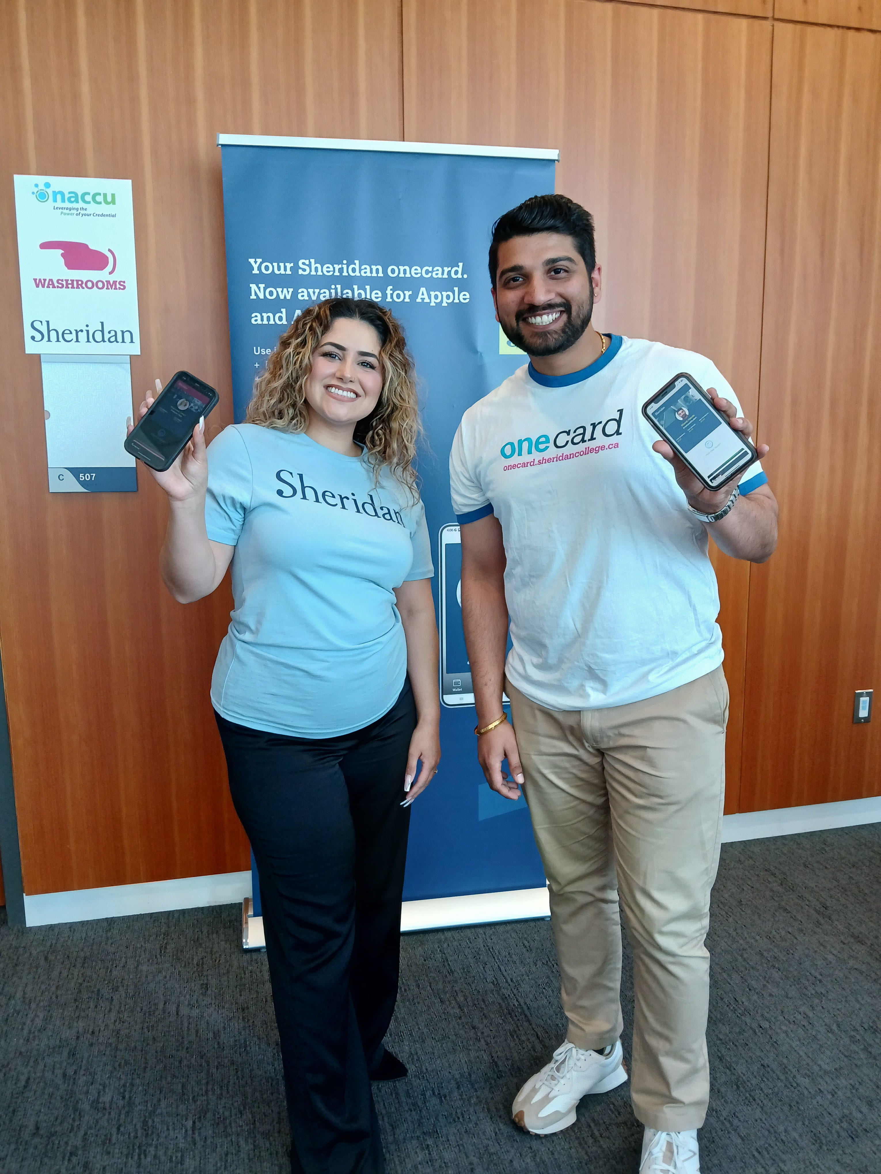 Two people hold up their cellphones displaying Sheridan's mobile onecard app