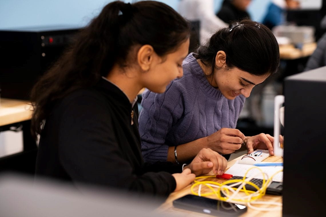 Two students working on an electrical task at a desk