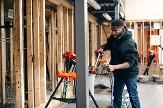 A tradesman uses machinery in a construction environment