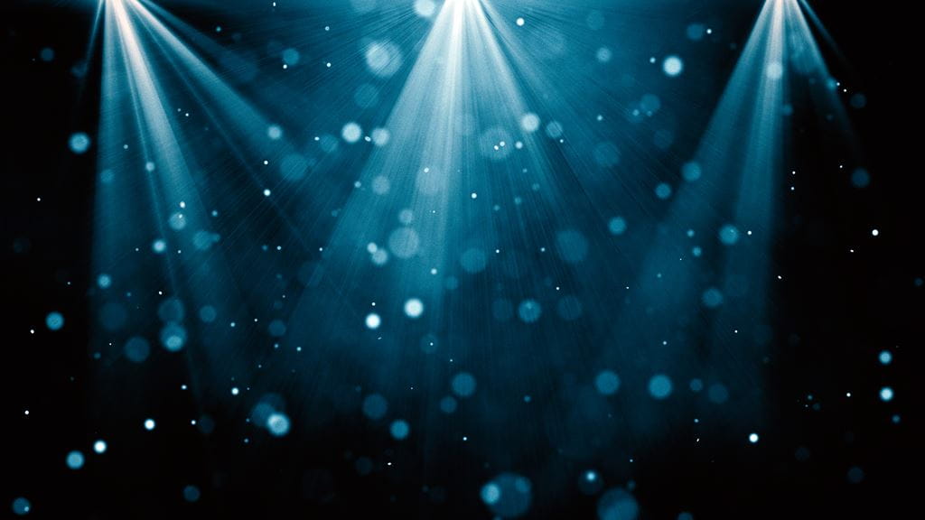 Three spotlights shine down on a stage