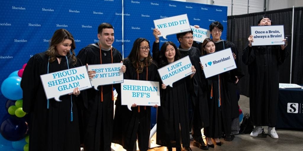 Graduating students hold signs commemorating convocation