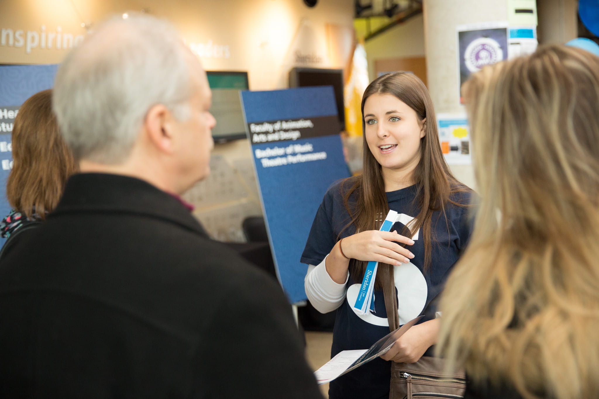 A Sheridan representative speaks with a prospective student and their family at Open House