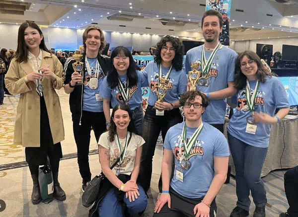 A group of students celebrate the success of the their game, Clean Getaway.