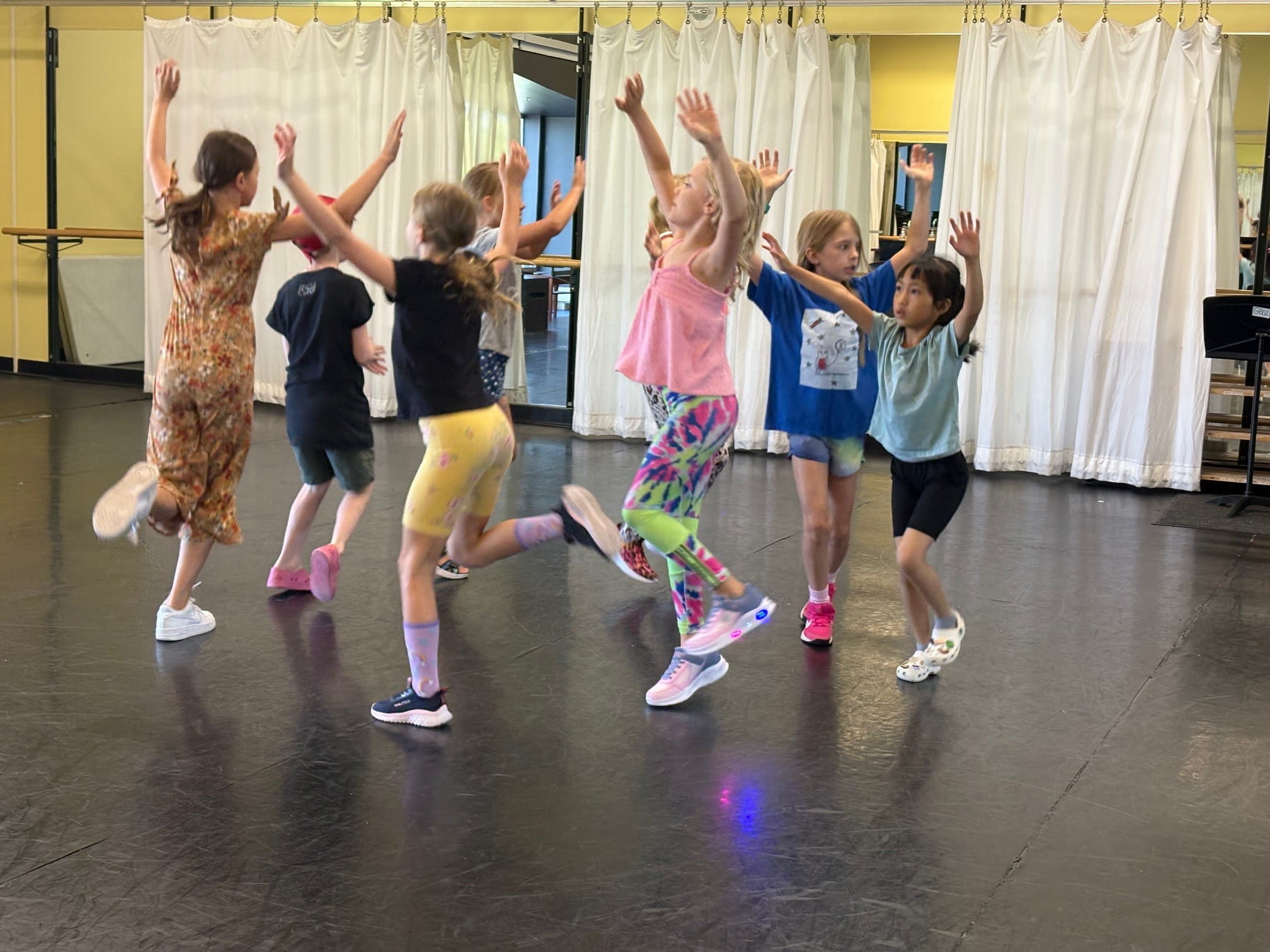 Campers at theatre camp dance as they move together in a circle.