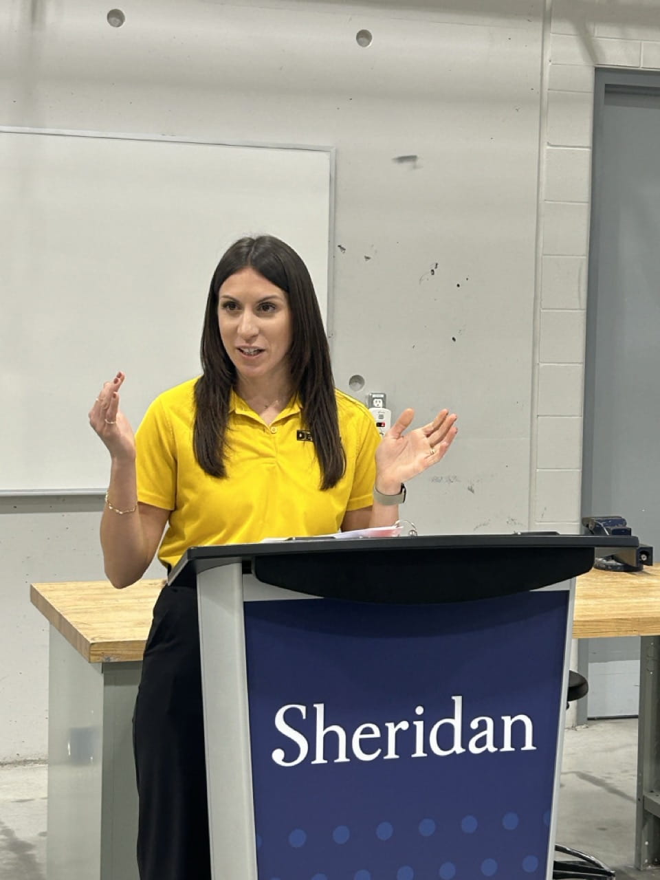DEWALT specialty sales manager Paula Brown is pictured speaking while standing behind a Sheridan podium
