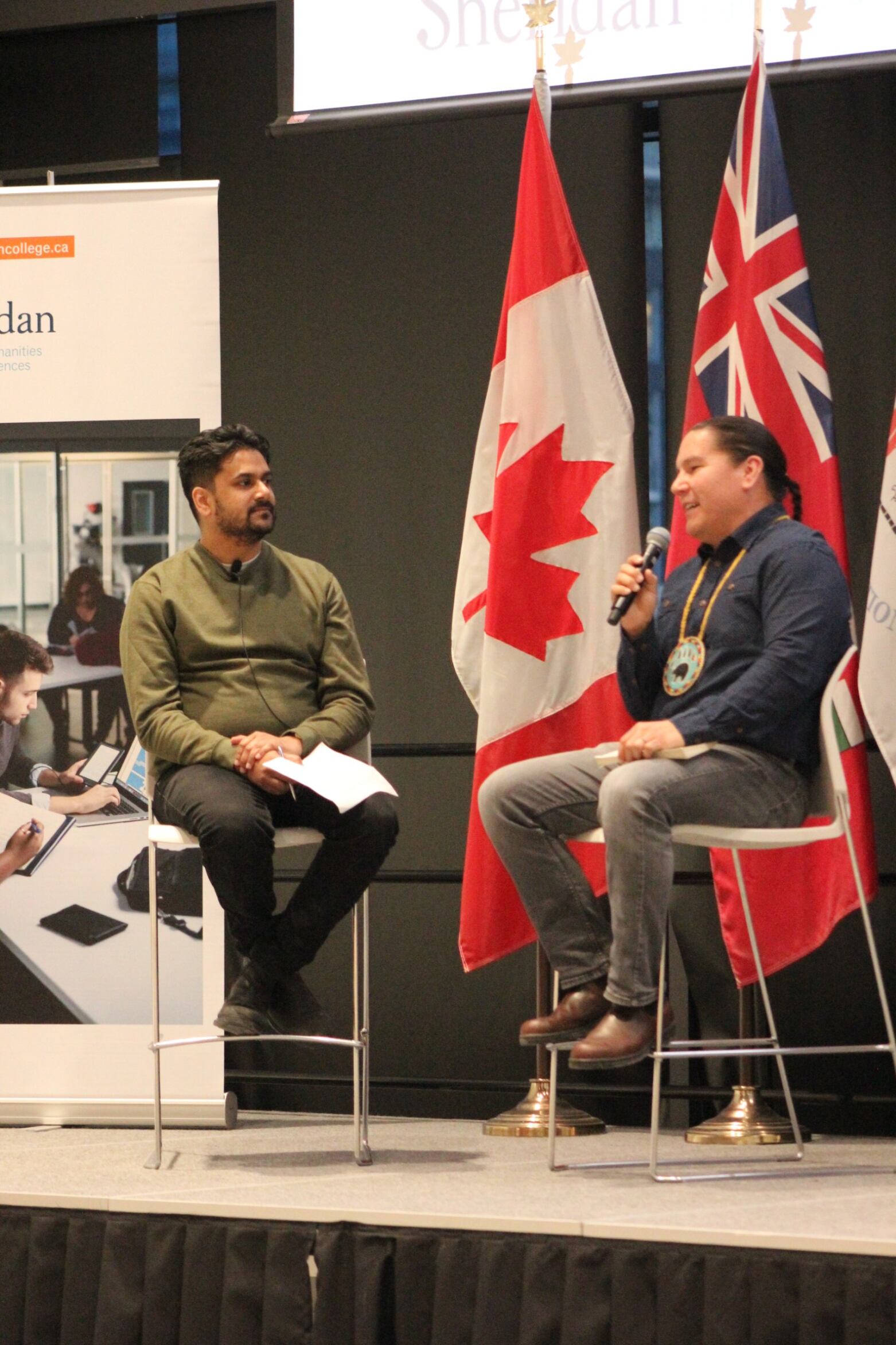 Sheridan Writer-in-Residence Naben Ruthum moderates a discussion on stage with celebrated Anishinaabe author and journalist Waubgeshig Rice