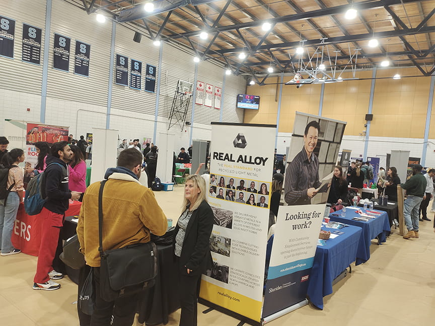 Students, graduates, employers and industry partners network during the Tech & Trades Career Fair in the gymnasium at Sheridan's Davis Campus